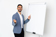 © luismolinero - Young caucasian man isolated on white background giving a presentation on white board