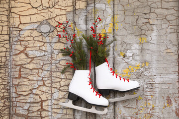 Wall Mural - Pair of ice skates with Christmas decor hanging on old wooden door