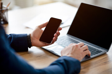 Aufkleber - Unrecognizable Arab businessman using laptop and cellphone with mockups for website or app design, cropped