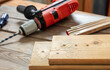 Drilling wood. Electric drill tool and planks on carpenter work bench table closeup view