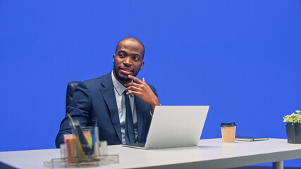 Aufkleber - Green Screen Office Background: Black Businessman Sitting at His Desk Working on a Laptop Computer. African American Man Thinking abou Big Data e-Commerce Analysis