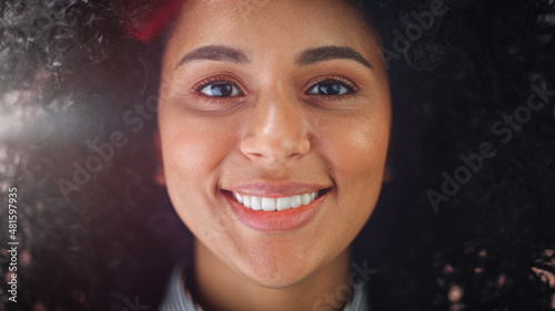 Fototapete Close-up Portrait of a Gorgeous Young African American Woman with Brown Eyes Smiling Charmingly. Happy Young Woman Enjoys Life, Success and Has Fun. Sun Shines on her Curly Afro Hair