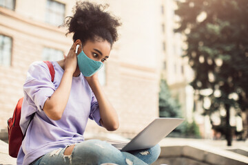 Wall Mural - Black Teenager Girl Using Laptop Wearing Face Mask Learning Outdoor