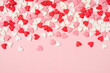 Leinwandbild Motiv Many colorful sugar hearts on pink background with copy space