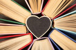 Love of books reading concept. Stack of books in the colored cover lay on the table. Heart shape card with empty space for your text. Valentines greeting card.