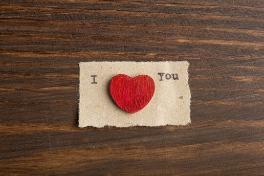 I love you - typed text. Valentines Day greetings concept. Little red wooden hearts close up. Valentines greeting card.
