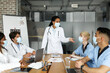 © Prostock-studio - International team of doctors in face masks having medical conference