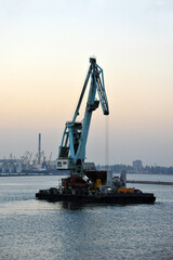 Wall Mural - Floating cargo crane at sunset