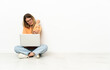 © luismolinero - Young woman with a laptop sitting on the floor with pain in elbow