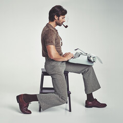 Wall Mural - Who needs a desk anyway. Studio shot of a 70's style businessman sitting on a stool using a typewriter.