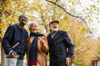 © LIGHTFIELD STUDIOS - Smiling asian man pointing with finger near cheerful interracial friends in autumn park.
