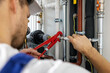 © ronstik - plumber working with pipelines. tighten plumbing fittings
