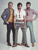 Premium Photo  Ready to kick it retro style. a studio shot of three men  clad in retro 70s wear holding a cassette player.