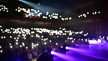 Live Rock Music Concert Crowd Of People Or Fans Shining Lights Or Flashlights. View From The Stage Fpv. Concert Hall Full Of Spectators Waving With Bright Lighters In The Air. Looking To The Crowd