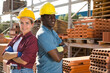 © JackF - Portrait of two confident multinational managers standing in a warehouse of construction materials. Close-up portrait