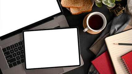 Contemporary workspace with laptop and tablet blank screen mockup.