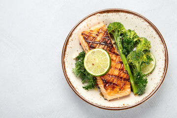 Wall Mural - Baked salmon with vegetables on light background.