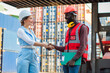 © Thanumporn - Happy dealing shaking hands two businesswoman and engineer working checking loading Containers box from Cargo freight ship for import export. shipping in docks.