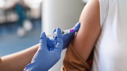 Wall Mural - Young Woman Receiving Vaccine Injection Sitting With Doctor Indoor