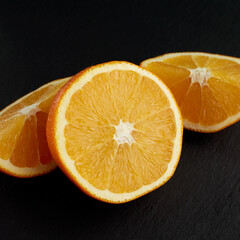 Wall Mural - Sliced orange on a dark gray background