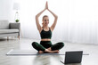 Satisfied caucasian beautiful young blonde woman practicing yoga in lotus position, exercising at home