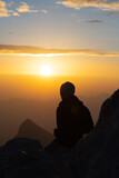 Fototapeta Natura - Silhouette of person watching sunrise form top of mountain
