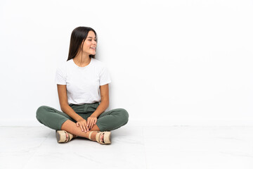 Wall Mural - Teenager girl sitting on the floor looking side