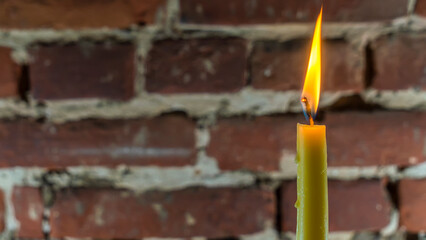 Wall Mural - Candle flame close-up on a light red wall background. Melted Wax Candle light border design. Long Exposure.