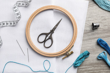 Canvas Print - Embroidery hoop, fabric and other accessories on wooden table, flat lay