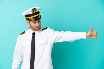 Wall Mural - Airplane caucasian pilot isolated on blue background giving a thumbs up gesture