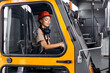 © alfa27 - Female worker driving loader in industrial container warehouse, looking confident, dressed in engineer uniform and hardhat orange helmet, concentrated on work. agriculture concept