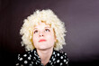Curly girl - blonde in funny clothes like a clown on a black background