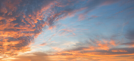 Wall Mural - dreamy sunset scenery with pink and orange lighted clouds, blue sky