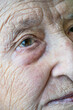 © berna_namoglu - closeup wrinkled face and eye of an old senior woman or man