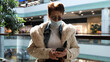 © emaria - Elderly woman in medical mask and eye glasses uses phone while walking in a shopping mall