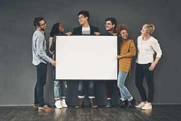 Poster - Market your idea here. Studio shot of a diverse group of people holding up a placard against a grey background.