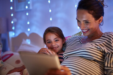 Can we read another one, Mom. Cropped shot of an attractive young woman reading her daughter a bedtime story.