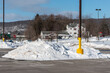 Snow plowed into large mounds in a parking lot in winter in Upstate NY.