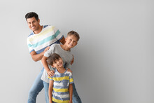 Happy Man And His Sons On Light Background
