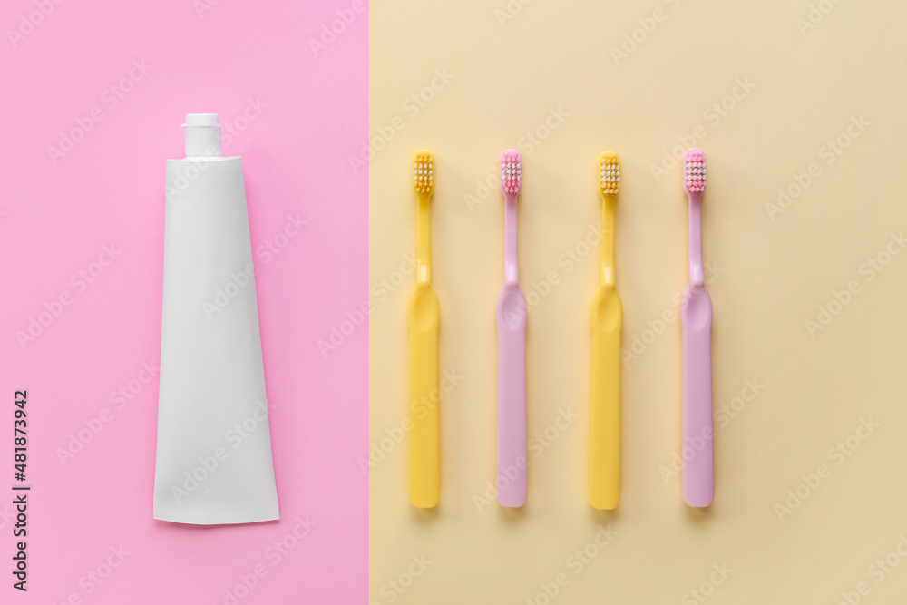 Tube with tooth paste and brushes on color background