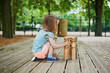 Adorable little girl on playground with bowls on a sunny day
