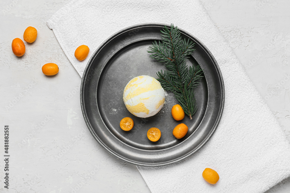 Composition with bath bomb, kumquat, fir branch and clean towel on light background