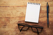 notatnik , długopis i okulary na drewnianym stole