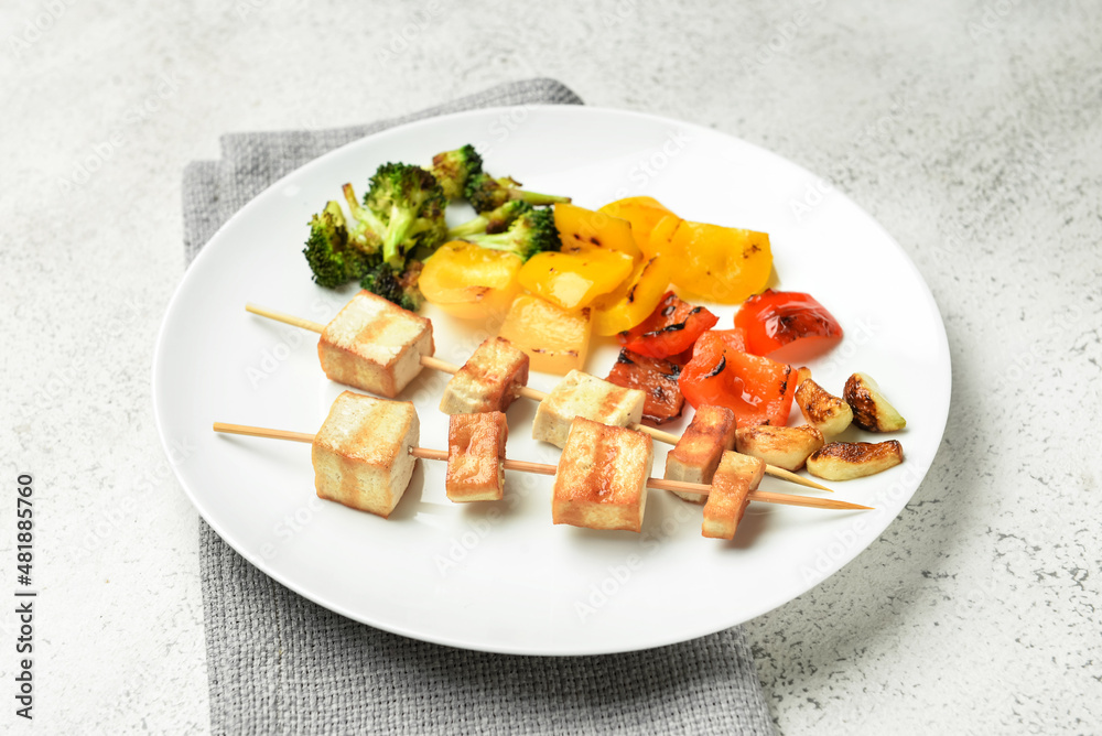 Plate with grilled tofu cheese skewers on light background, closeup