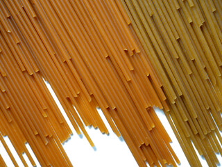 Pasta on the table. Spaghetti of two types on a white background. Tomato and buckwheat pasta. Italian food. Cuisine of the peoples of the world. Cooking food.