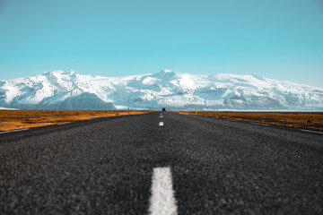 Iceland view of vast landscape with camera placed in middle of two lane road