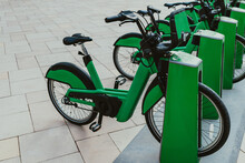 Green Eco-friendly Bike Public Rentals In A Row Located Outside In A Park Area