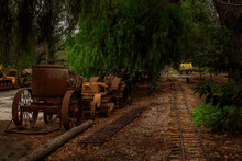 Old Train Tracks And Abandoned Heavy Equipment Amongst Trees In A Rural Setting