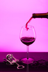 Wall Mural - glass goblet of red wine on a lila background