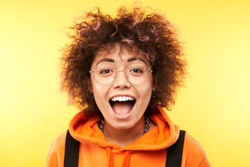 Shocked kazakh girl face with afro curls and tourist backpack looks surprised close-up on white studio background